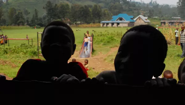 Children peer through window of a school in the DRC.
