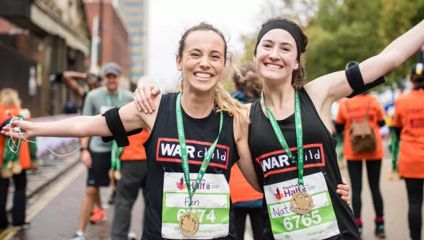 Runners smile after finishing the Royal Parks Half Marathon for War Child.