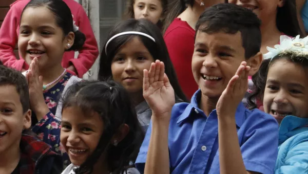 A group of children in Colombia laughing and clapping