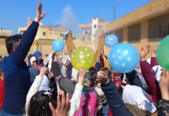 Children and War Child partner staff playing at a child friendly space in Syria with balloons