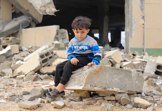Child sitting on rubble in Gaza. 