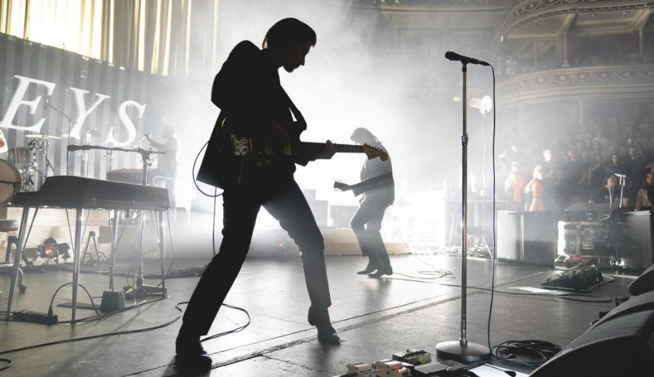 Black and white image of Arctic Monkeys performing for War Child.