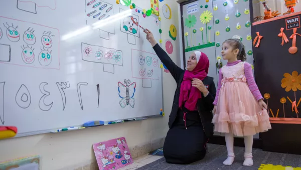 Education facilitator teaching students in a War Child temporary learning space in Jordan.
