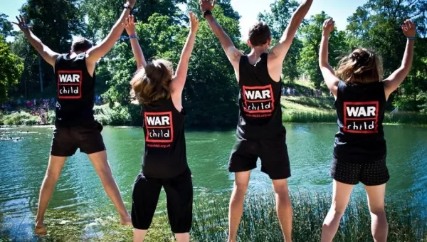 War Child staff members jump in the air at Wilderness Festival