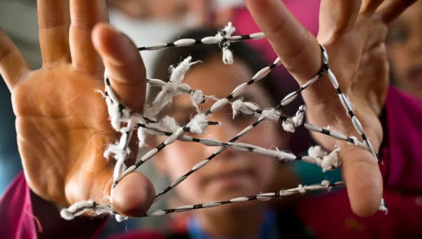 Child plays cats cradle at War Child child-friendly space.