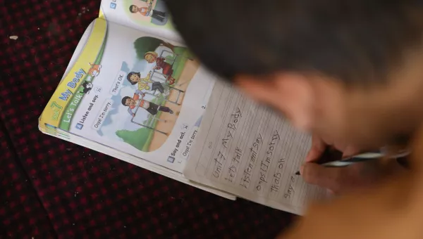 Participant Hassan does homework in Afghanistan.