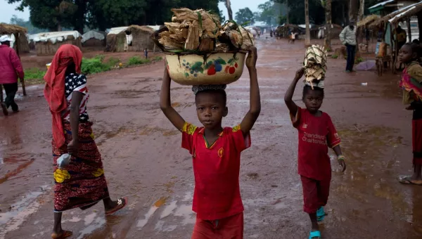 Little boys carry fire food above their heads.