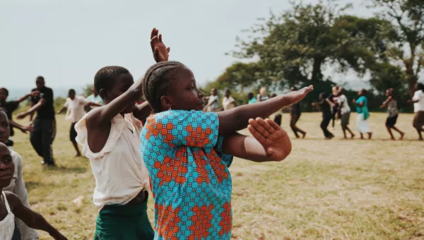 Participants laugh as they dance together outside their War Child supported school in Uganda.