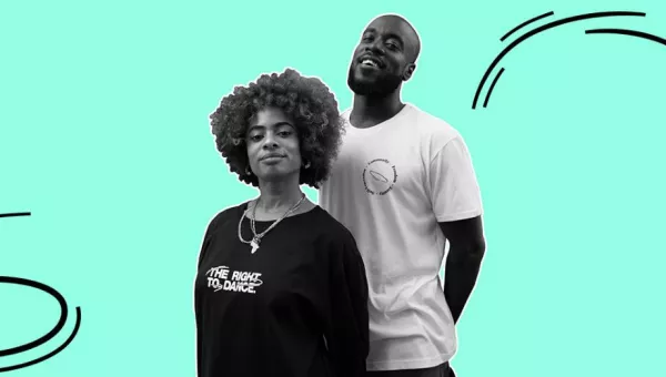 Two people posting in TRTD merch. One in a black sweatshirt with white logos, and the other is a white t shirt with the core values on it 