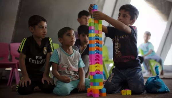 Iraqi boys sit on the floor playing with building blocks together in a War Child child-friendly centre in Iraq.