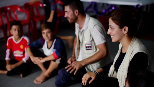 War Child staff member plays games with children in child-friendly space in Iraq.