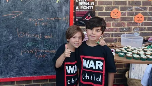 Boys fundraising for War Child at school with a bake sale.
