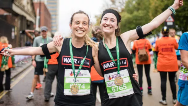 Runners smile after finishing the Royal Parks Half Marathon for War Child.