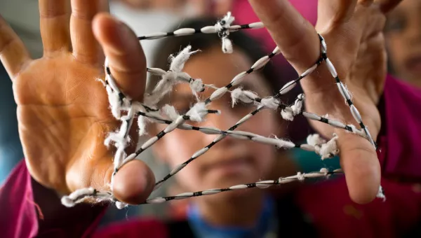 Child plays cats cradle at War Child child-friendly space.