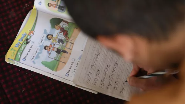 Participant Hassan completes his homework in Afghanistan.