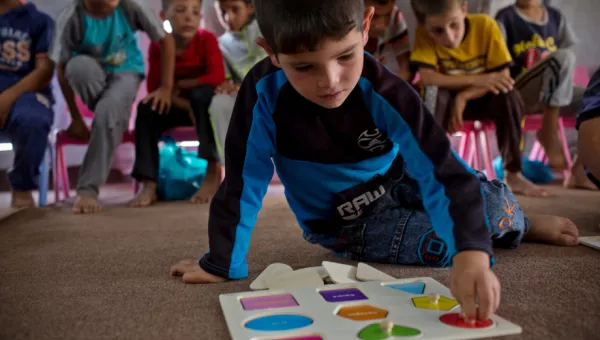Participant playing with a game in a War Child child-friendly space in Iraq.