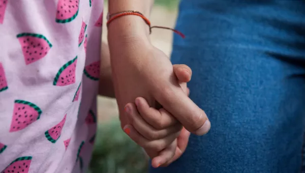 War Child staff member holds participants hand.