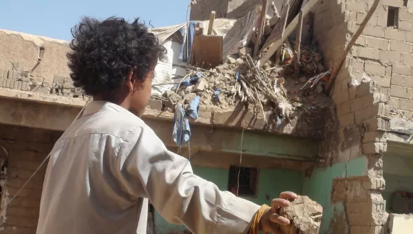 Yemeni child looks at the destruction caused to his village by conflict.