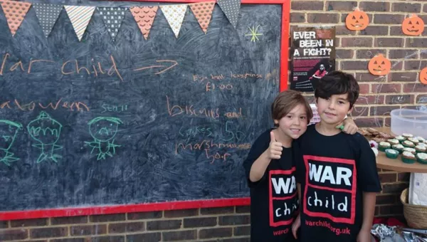 Two children in War Child t-shirts at their fundraising event,