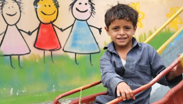 Participant plays on a slide outside one of War Child’s centres in Yemen.