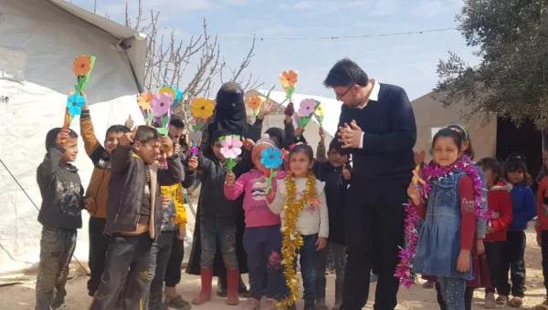 Children and War Child partner staff playing at a child friendly space in Syria with paper flowers