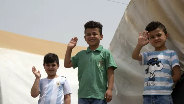 Children waving at a camp in Iraq. 