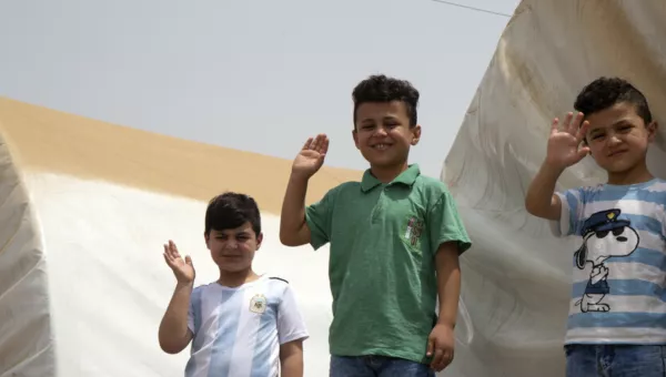 Children waving at a camp in Iraq. 