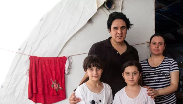 A family in Iraq standing outside their temporay home. 