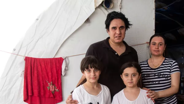 Family standing outside their temporary home in Iraq. 