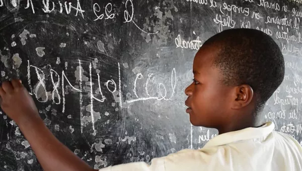 Lamegi drawing on a chalk board in DRC.