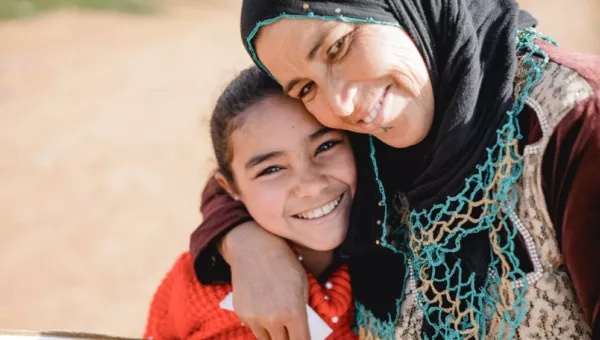 A mother and daughter smiling together. 