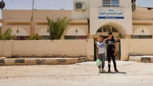 Ali and his friend standing outside of a War Child safe space.