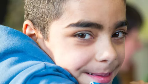 A boy smiling in a classroom in Ukraine.