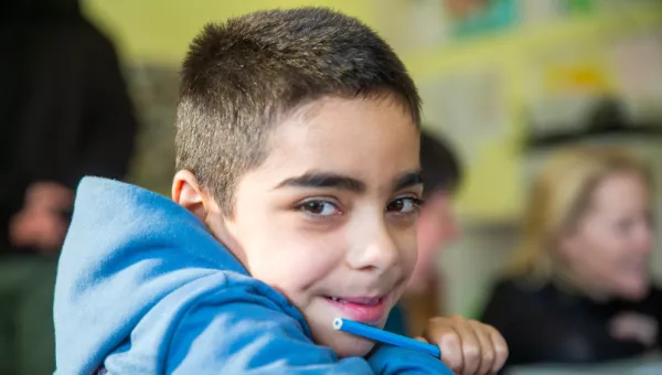 A boy smiling in a classroom in Ukraine. 