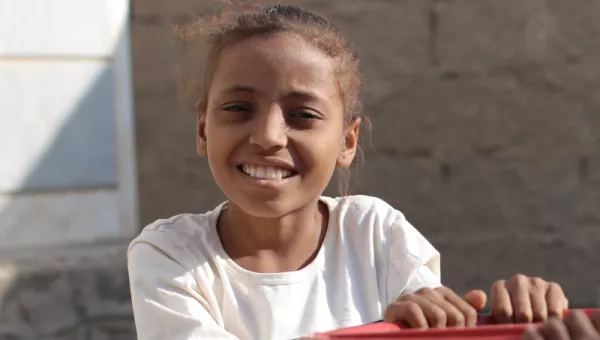 A girl on a roundabout in Yemen.