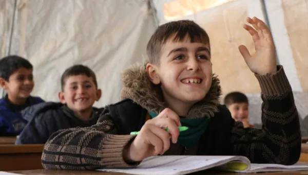 A child smiling whilst in a War Child classroom in Syria. 