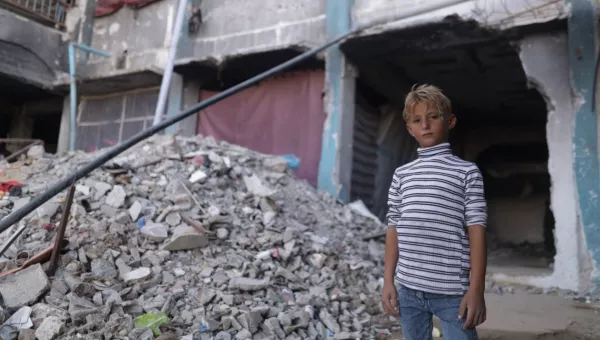 Boy in Gaza next to rubble