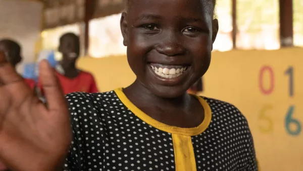 Abuk smiling and waving