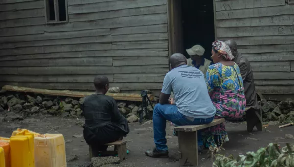 A family sat outside their house in DRC.