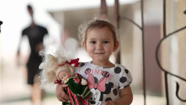 A young girl holding a doll.