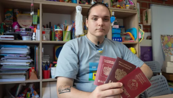 Ivan sat in a classroom holding 3 passports.