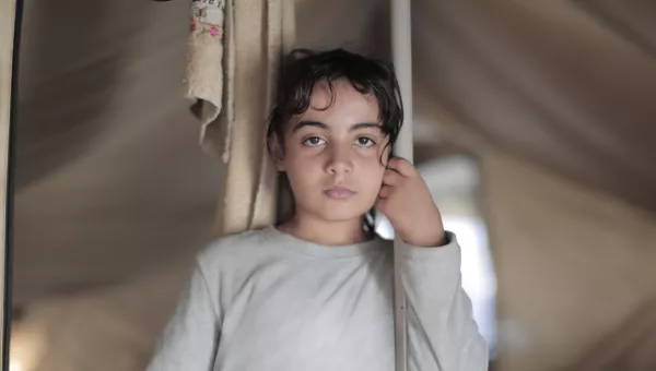 girl in tent stares into camera