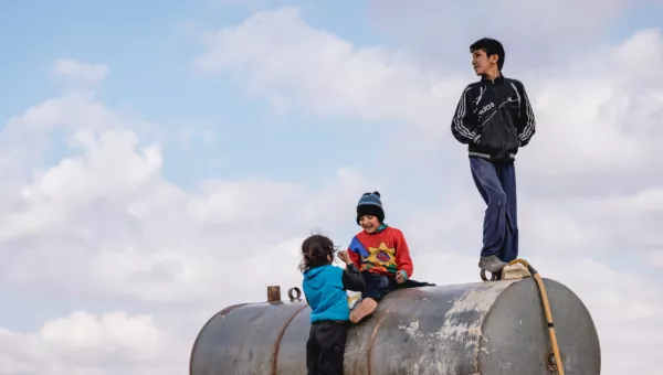 Children standing on a metal tube