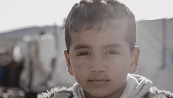 small boy in coat looks at camera