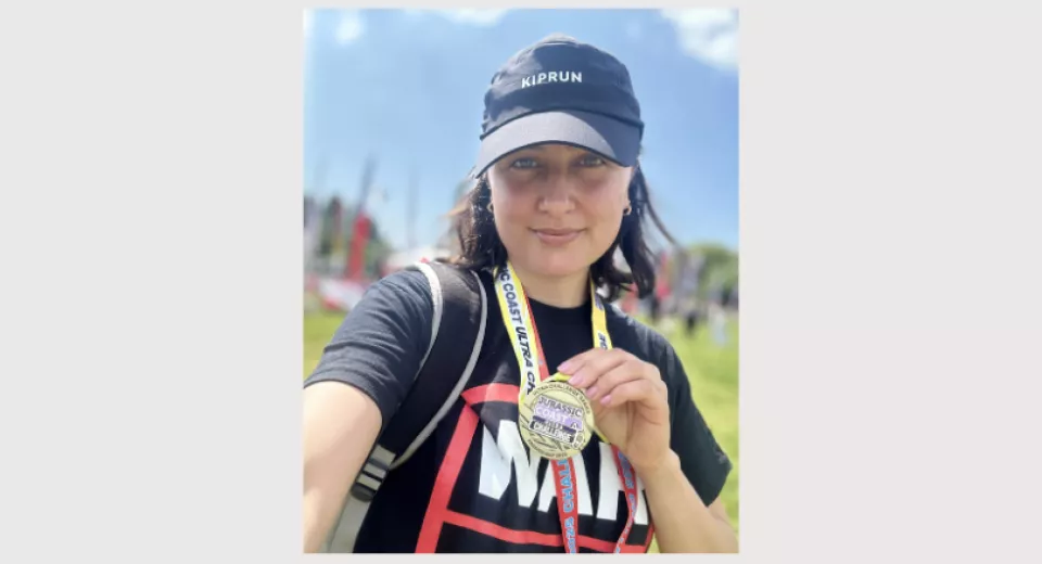 Zuhal holding her medal for the Jurassic Coast Challenge