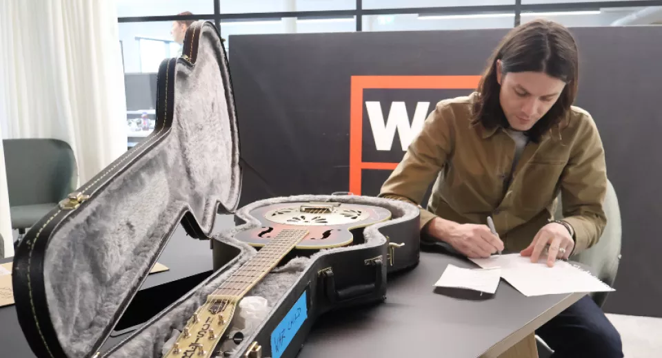 James Bay signing items for the Spring Clean auction in 2025.
