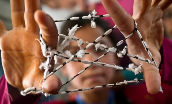 Child in Iraq plays cats cradle at a War Child child-friendly space.