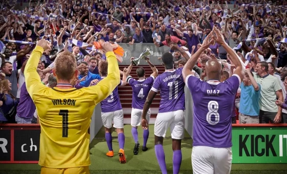 Football players from Sports Interactive's Football Manager hold up cup to cheering fans.