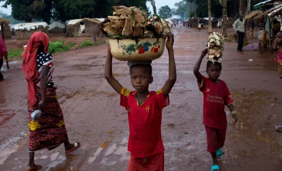 Little boys carry fire food above their heads.