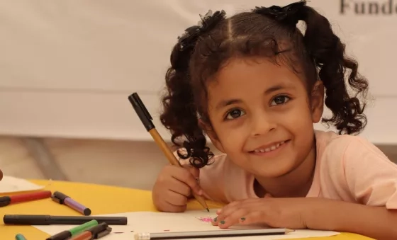 A young girl smiling at a War Child learning Centre. 